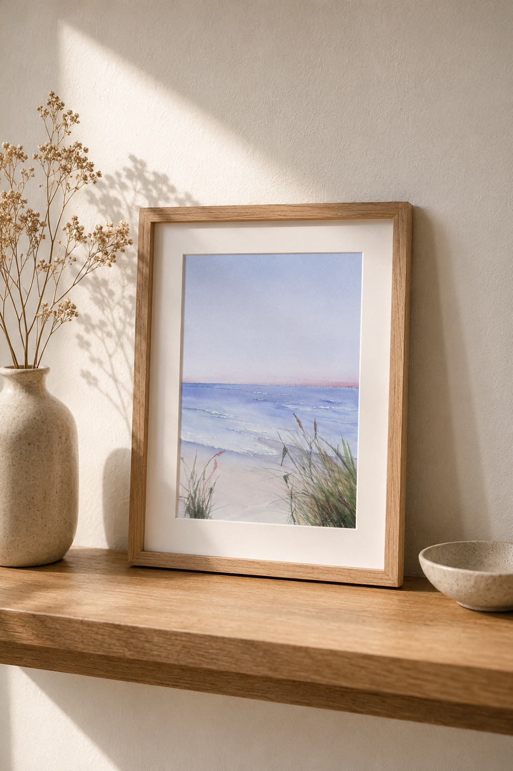 Minimalist watercolor painting of a calm pastel seashore with soft waves and dune grass in gentle morning light.